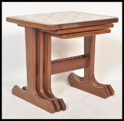A retro 20th Century teak wood tile top nest of graduating tables, the graduating tables raised on L