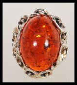 A large sterling silver dress ring in the Art Nouveau style having floral monts with large faux