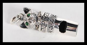 A sterling silver novelty whistle pendant in the form of a cat with emerald eyes. Weighs 10 grams.