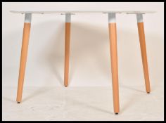 A contemporary white laminated and ash dining table. The table comprising of a laminated wooden
