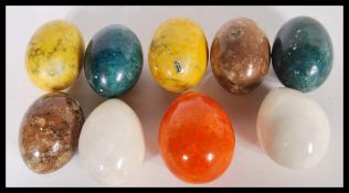 A collection of 20th Century geological marble eggs of different colours including green, yellow,