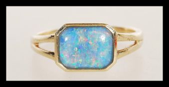 A hallmarked 9ct gold ring having a central octagonal bezel set opal cabochon doublet. Weighs 1.9