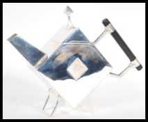 A silver plated tea poct in the style of Christopher Dresser, being of angular form with a pierced