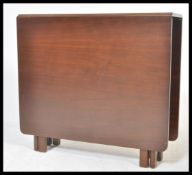 A 1970's 20th century Nathan teak wood drop leaf dining table. The full length drop leaves being