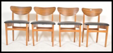 A set of four vintage retro 20th Century teak wood dining chairs raised on square legs with black