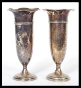 A pair of Edwardian early 20th Century silver hallmarked tulip vases, raised on pedestal bases