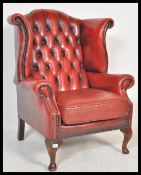 An antique style Chesterfield red oxblood leather armchair arm chair raised on cabriole legs with