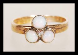 A 20th Century 9ct gold ring set with three opal cabochons. Marks rubbed but tests as 9ct. Weight