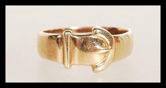 A hallmarked 9ct gold band ring in the form of a belt and buckle. Weighs 3.4 grams size M.