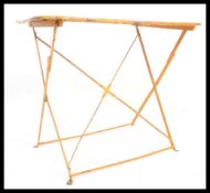 A vintage retro 20th Century folding metamorphic table of circular form having cross action legs