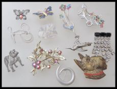 A collection of vintage brooches to include a brass scottie dog brooch, an enamelled butterfly
