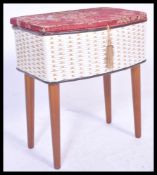 A vintage retro 20th Century sewing box raised on cylindrical tapering legs with white wicker body