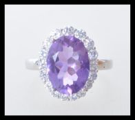 A stamped 925 silver ladies dress dring set with a large faceted amethyst stone with a halo with