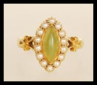 A stamped 18ct gold ladies dress ring set with a marquise cut green stone set with a halo of seed
