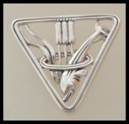 A stamped Sterling silver George jensen style brooch of triangular form featuring a dolphin.