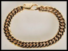A large and heavy hallmarked 9ct gold gents curb link bracelet chain having a lobster claw clasp.