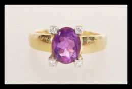A 20th Century 18ct gold ring set with an oval cut amethyst in a prong setting with diamond accent
