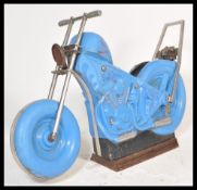 A vintage 20th Century fairground carousel ride in the form of a motorbike having blue moulded