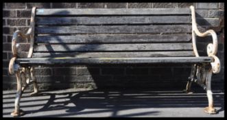An early 20th Century large three seater cast iron and wooden slatted garden bench. Good weathered