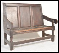 An 18th century country oak hall settle bench raised on block and turned legs with peripheral