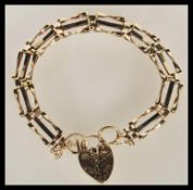 A 9ct gold 375 hallmarked ladies bracelet with heart shaped padlock and safety chain. Total weight