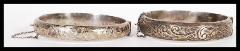 Two early 20th Century hallmarked silver bangle bracelets of circular form having engraved
