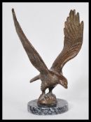 A 19th Century bronze large figurine in the form of an eagle in flight raised on circular blue