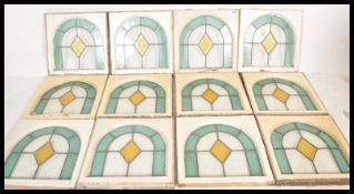 A set of 12 Art Deco leaded and stained glass windows (circa 1928) having domed tops with light blue