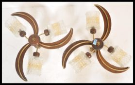 A pair of vintage retro 20th century teak wood three branch ceiling lights having frosted mottled