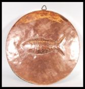 A vintage early 20th Century large circular copper fish mould / wall charger in the manner of