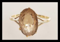 A 9ct gold ladies dress ring with inset large oval facet cut smoky quartz, weight 3.3g / Size Z1