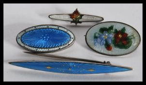 A group of four sterling silver and enamel set danish brooches in the Georg Jensen or Charles Horner