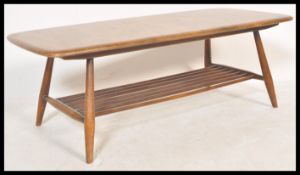 A retro 20th Century Ercol Golden Dawn beech and elm coffee table raised on tapering supports united