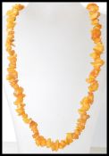 A vintage 20th Century butterscotch amber type strung necklace the polished 'pebbles' of varying