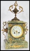 A 19th Century French Empire mantel clock having a green marble case. The white enamel face having