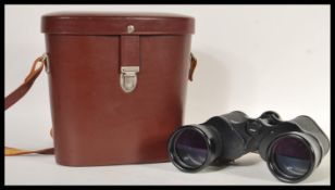 A pair of vintage Carl Zeiss Jena Jenoptem binoculars (10x50 W) in a brown leather case. Measures