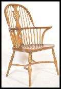A good quality Victorian style beech and elm wood Windsor chair / armchair being raised on turned
