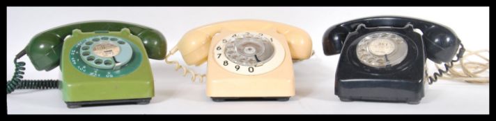 A set of three vintage retro 20th Century bakelite ring dial telephones in cream, green and black