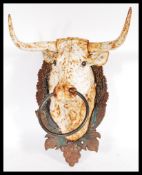 A  20th Century cast iron horse teather in the form of a cow / bull having grape and vine back plate