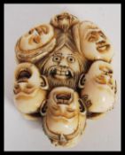 A 20th Century Japanese netsuke or toggle of composite ivory or bone effect in the Twelve Faces