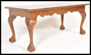 A good quality mahogany and walnut Queen Anne revival rectangular coffee table being raised on