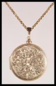 A 9ct gold round shaped hallmarked locket with engine turned decoration being set to a 9ct gold