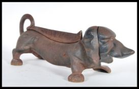An early 20th Century cast iron boot scraper scrape in the form of a Dachshund dog. Measures 15 cm