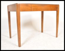 A vintage mid 20th Century golden oak Utility writing table desk being raised on squared tapering
