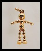 A hallmarked 9ct gold necklace pendant in the form of an articulated man with ball head and