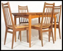 A vintage retro 20th Century teak Danish influence dining table suite with a set of four vintage