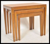 A vintage retro 20th Century teak wood nest of three tables raised on rounded tapering legs.