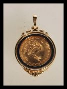 A 9ct gold necklace pendant inset with a 1/10 South African gold Krugerrand coin dated 1985. Total