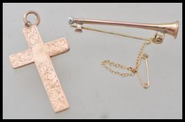 A hallmarked 9ct gold crucifix pendant along with a 9ct gold stamped bar brooch in the form of a