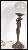 An Art Nouveau bronze effect table lamp in the form of a maiden holding a large globular